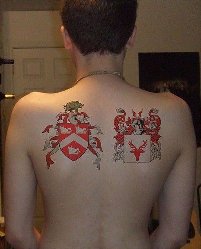 Red And Grey Two Family Crest Tattoo On Man Upper Back