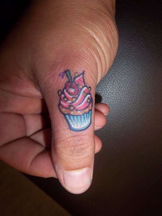 Tiny Colorful Cupcake Tattoo On Hand Thumb