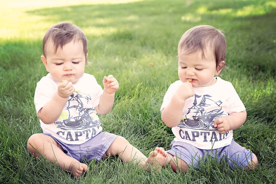 Twin Baby Boys Sitting On Grass