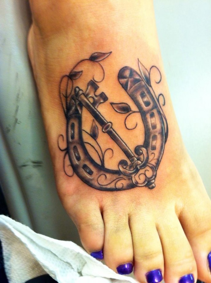 Amazing Black Key In Horseshoe Tattoo On Girl Foot