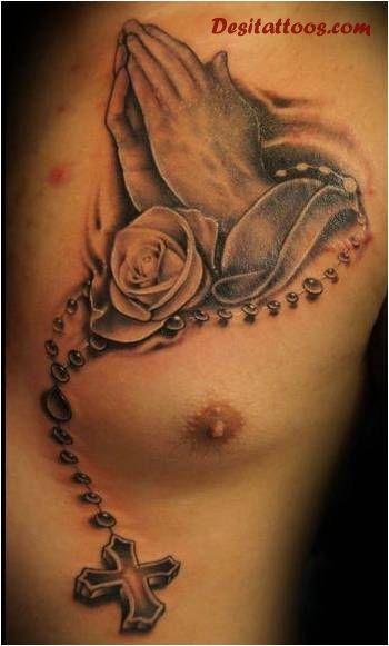 Black And Grey 3D Religious Rosary Cross On Praying Hand With Rose Tattoo On Man Chest