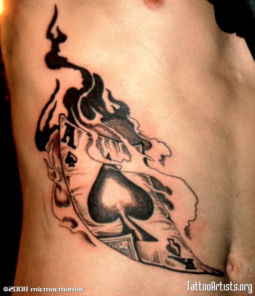 Black And Grey Ace Of Spade In Flame Tattoo On Side Rib