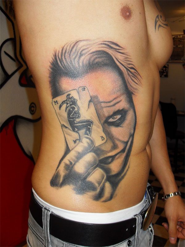 Black And Grey Joker With Play Card Tattoo On Man Side Rib