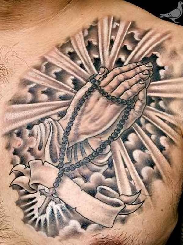 Black And Grey Religious Rosary Cross In Praying Hands With Banner Tattoo On Man Chest