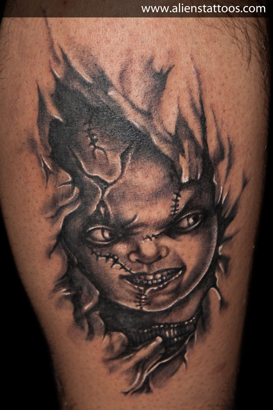 Black And Grey Ripped Skin Horror Chucky Face Tattoo On Leg Calf