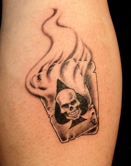 Black And Grey Skull In Ace Of Spade In Flame Tattoo Design