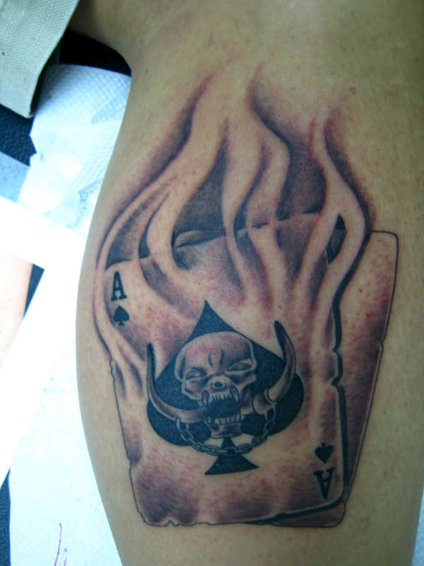 Black And Grey Skull In Ace Of Spade In Flame Tattoo On Leg Calf