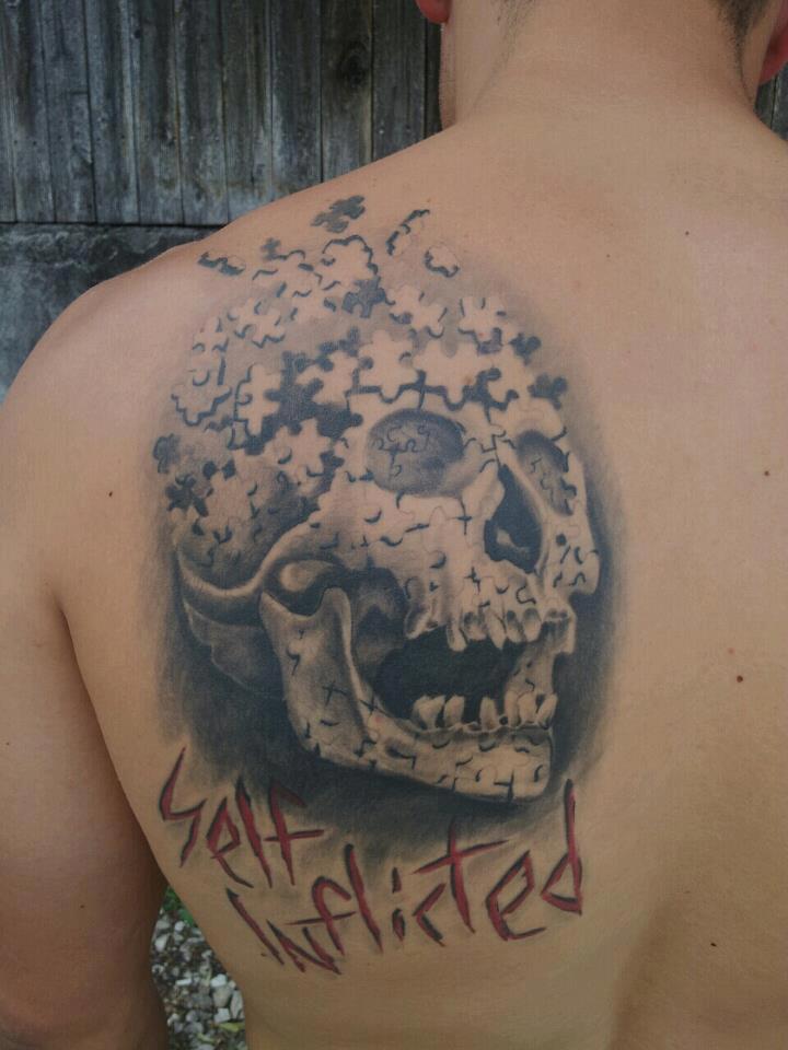 Black And Grey Skull Puzzle Tattoo On Man Left Back Shoulder