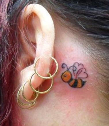 Black And Orange Bee Tattoo On Girl Behind The Ear