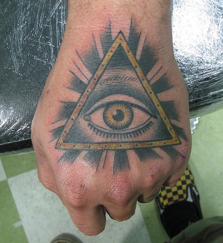 Black And Yellow Illuminati Eye Tattoo On Hand