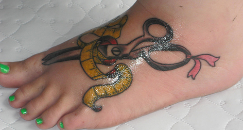 Black Scissor With Yellow Inch Tape Tattoo On Girl Foot