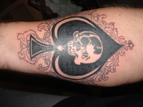 Black Skull In Ace Tattoo On Forearm