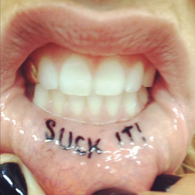 Black Suck It Tattoo On Inner Lip