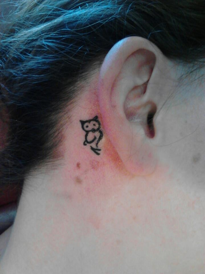 Black Tribal Owl Tattoo On Girl Behind The Ear
