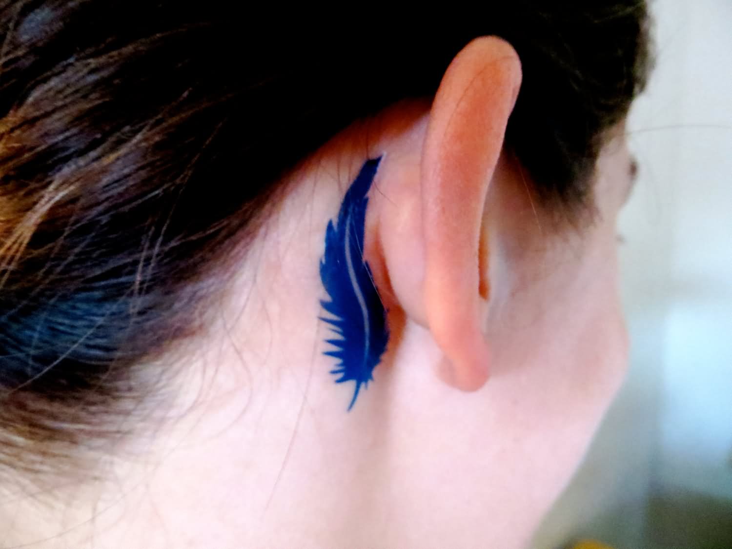 Blue Feather Tattoo On Girl Behind The Ear