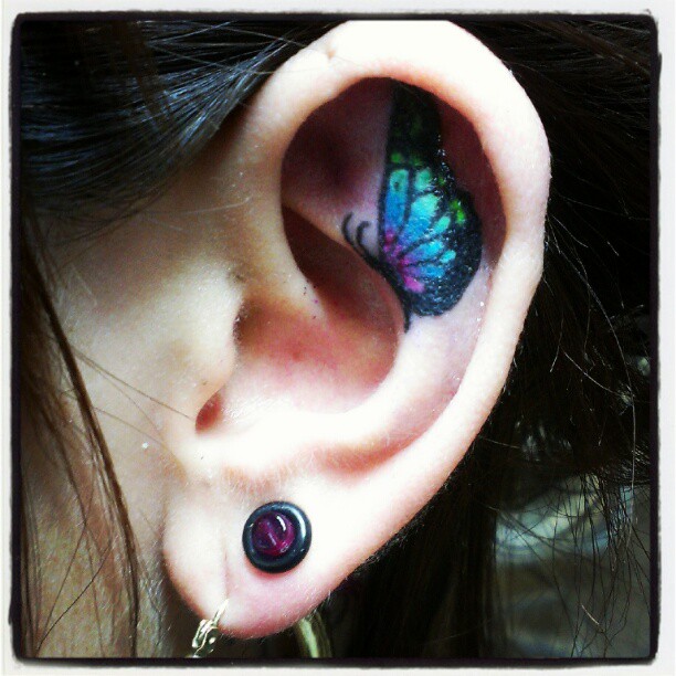 Colorful Butterfly Tattoo On Girl Inside The Ear