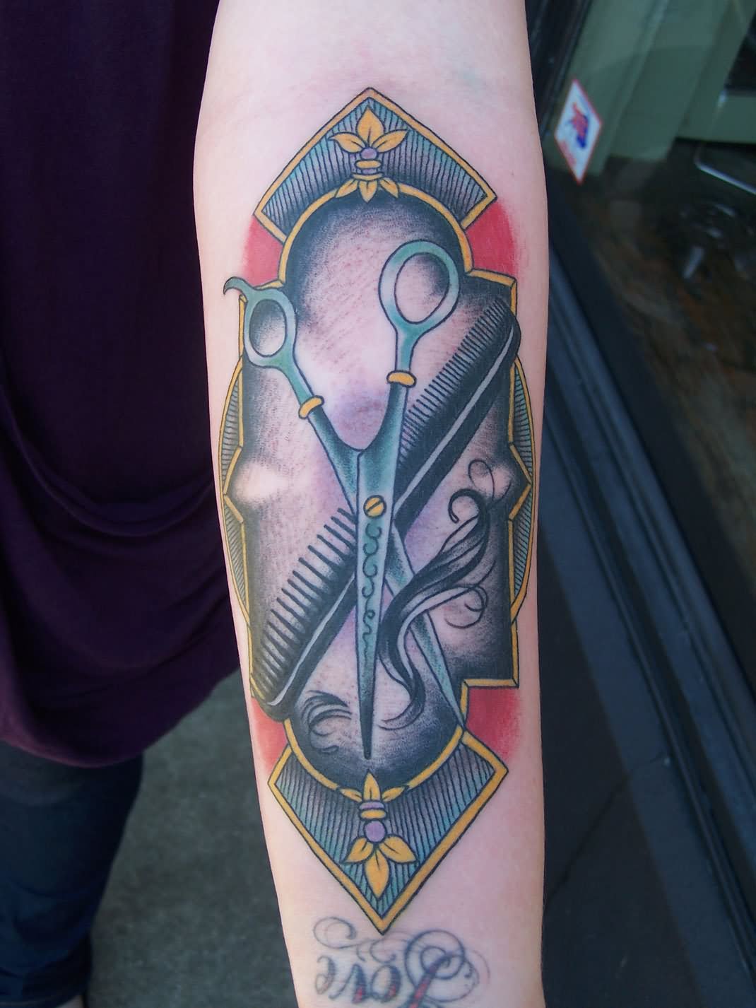 Colorful Scissor And Comb In Frame Tattoo On Forearm
