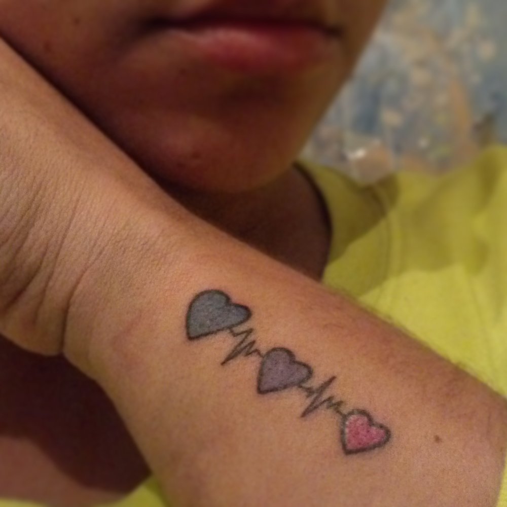 Colorful Three Hearts With Heartbeat Tattoo On Side Wrist
