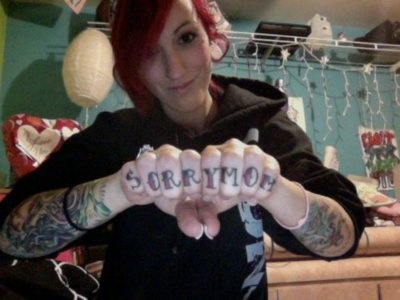 Girl Showing Sorry Mom Tattoo On Fingers