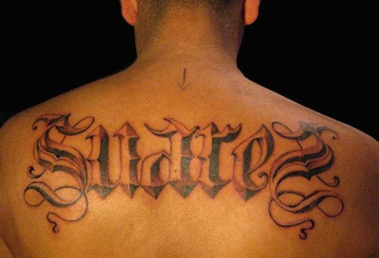 Grey Ink Wording Tattoo On Upper Back