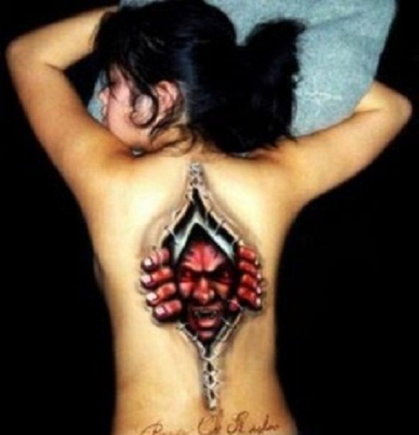 Red 3D Monster Face In Ripped Skin Tattoo On Girl Full Back