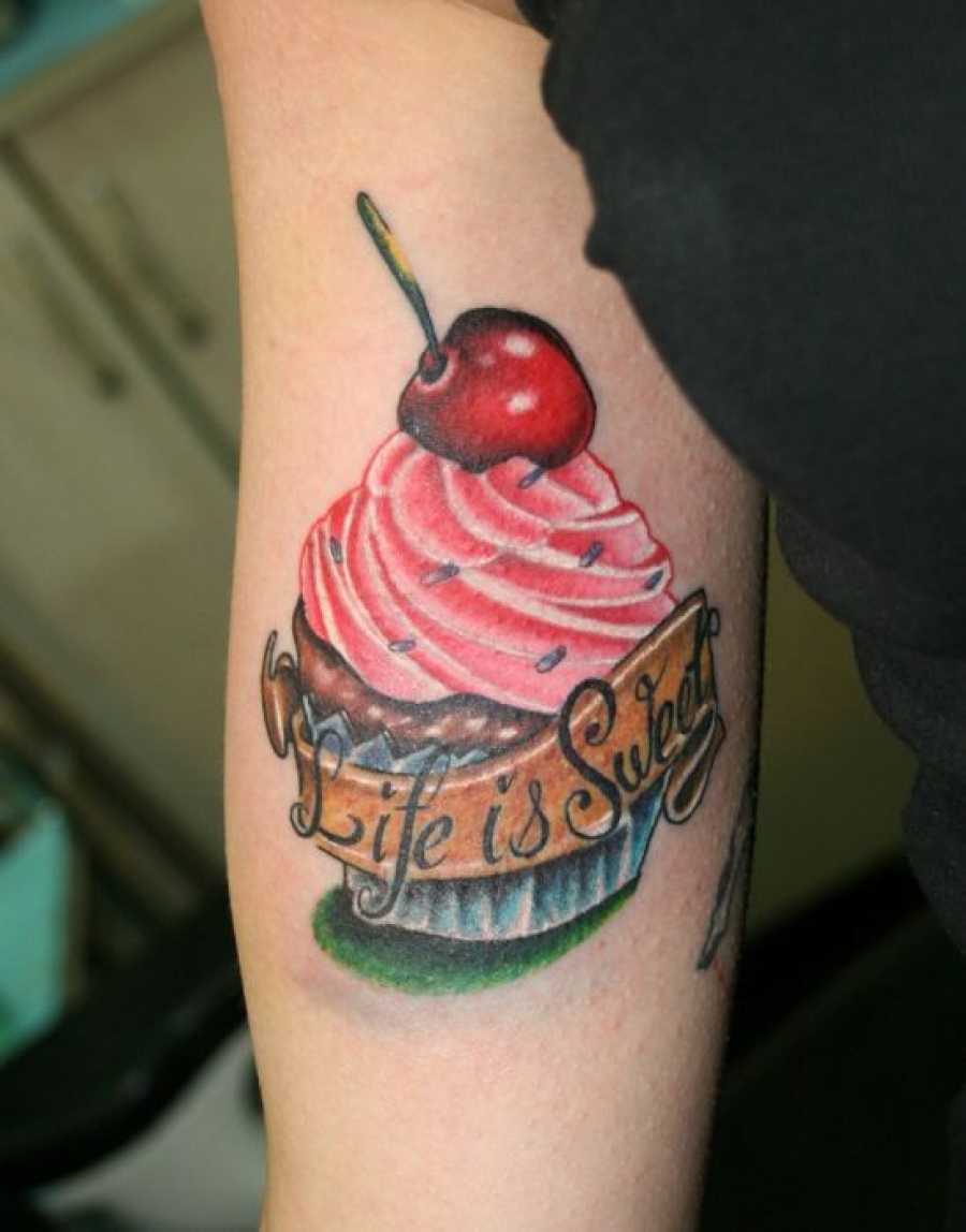 Red Cherry On Cupcake Tattoo On Bicep