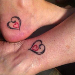 Red Tiny Heart In Black Heart Tattoo On Heel And Foot For Daughter