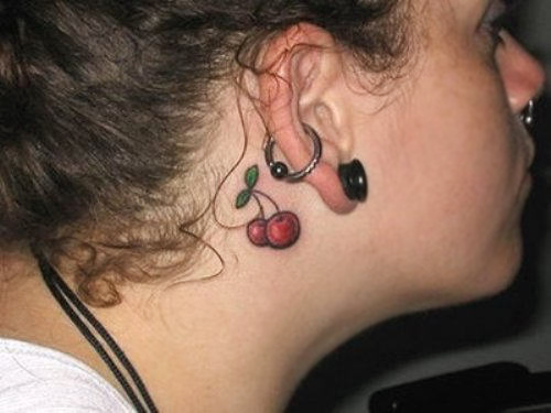 Red Two Cherry Tattoo On Girl Behind The Ear
