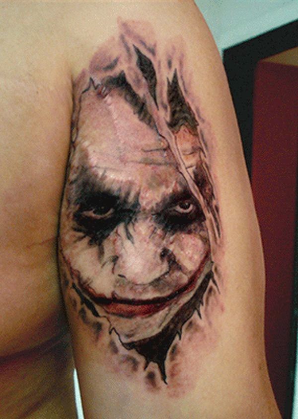 Ripped Skin Joker Face Tattoo On Bicep