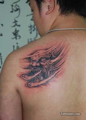 Ripped Skin Monster Face Tattoo On Man Back Shoulder