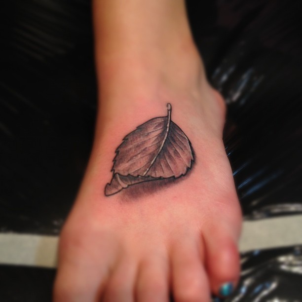 Black And Grey 3D Leaf Tattoo On Girl Foot