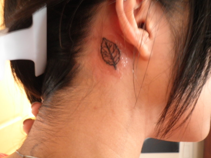 Black Leaf Tattoo On Girl Behind The Ear