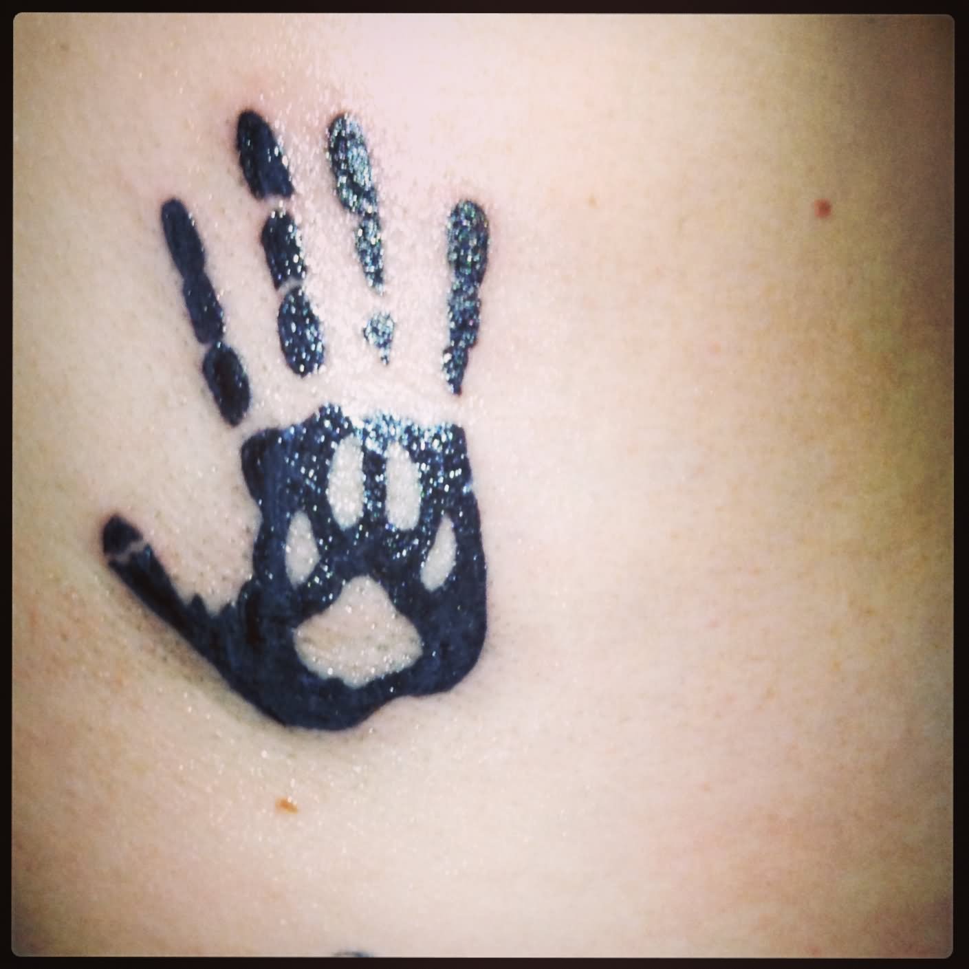 Black Paw In Hand Print Tattoo Design