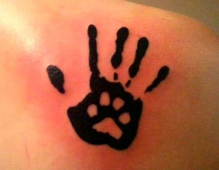 Black Paw In Hand Print Tattoo On Back Shoulder
