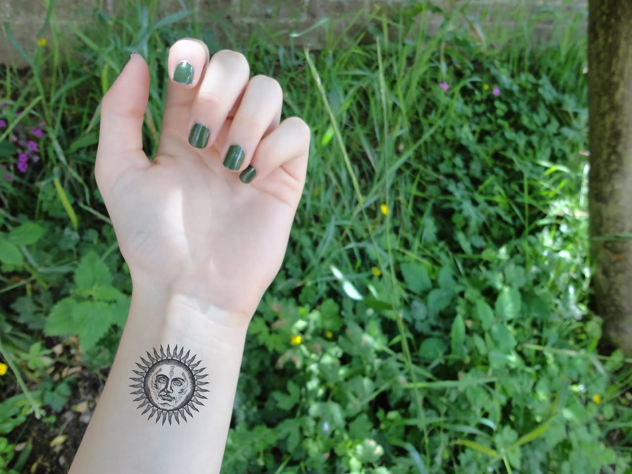 Black Sun Face Tattoo On Girl Wrist