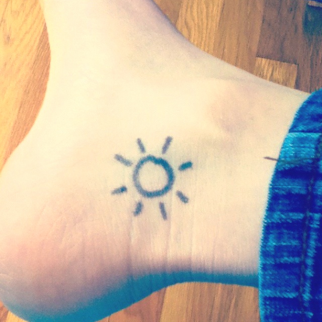 Black Tiny Sun Tattoo On Ankle