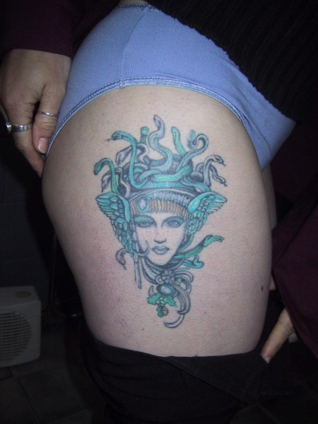 Green And Grey Medusa Face Tattoo On Thigh