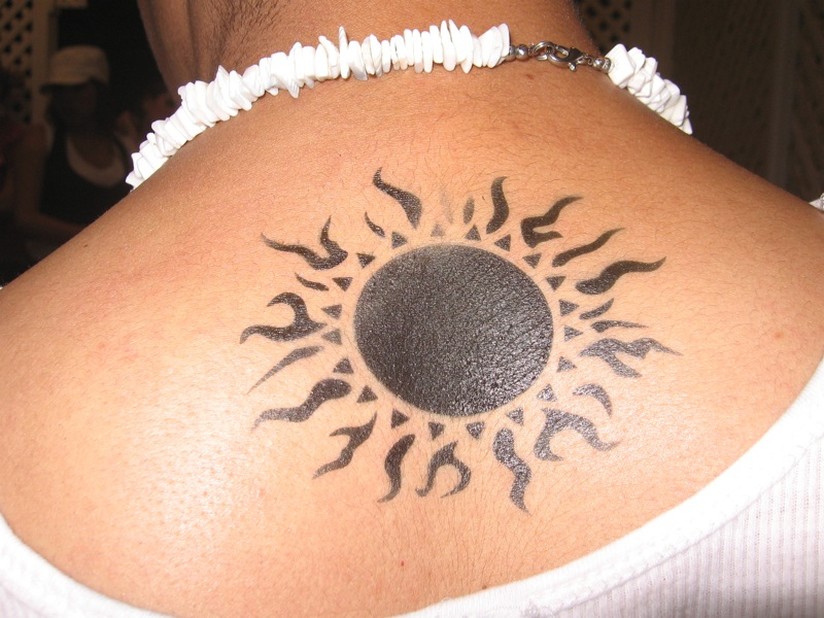 Silhouette Tribal Sun Tattoo On Girl Upper Back