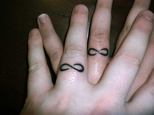 Awesome Black Infinity Ring Tattoo On Couple Finger