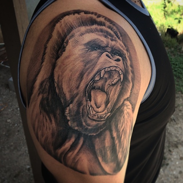 Black And Grey 3D Roaring Gorilla Head Tattoo On Man Shoulder