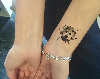 Black And Grey Ladybird Tattoo On Wrist
