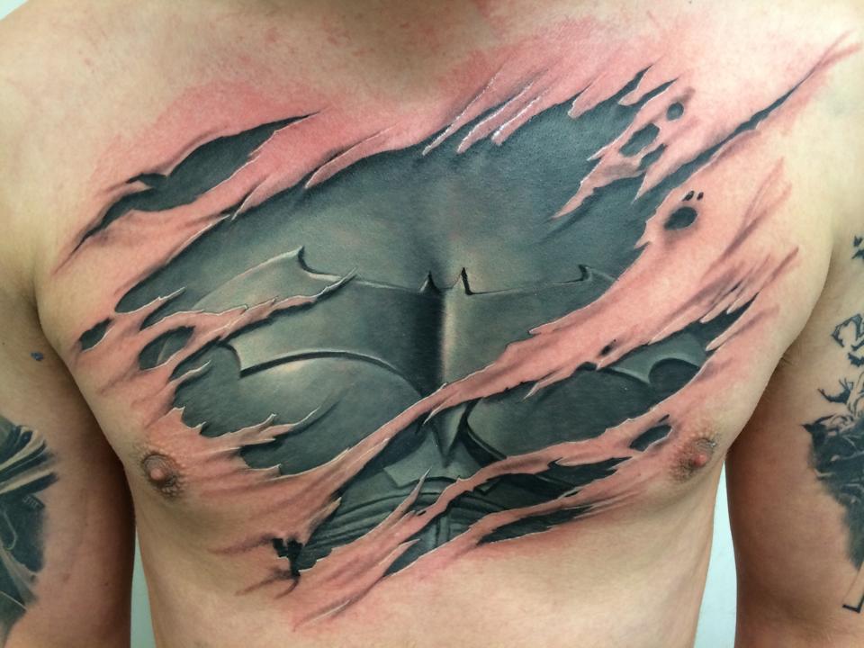 Black And Grey Ripped Skin Batman Costume Tattoo On Man Chest By Paul Boxall