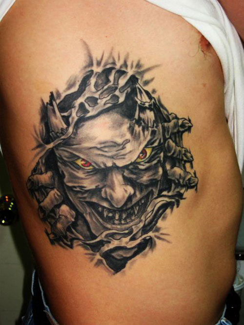 Black And Grey Ripped Skin Demon Face Tattoo On Man Side Rib By Patsy Grieco