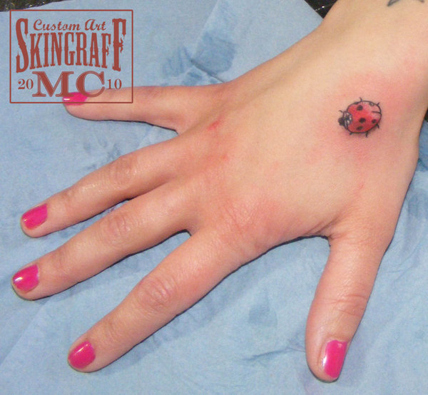 Black And Red Little Ladybird Tattoo On Girl Hand