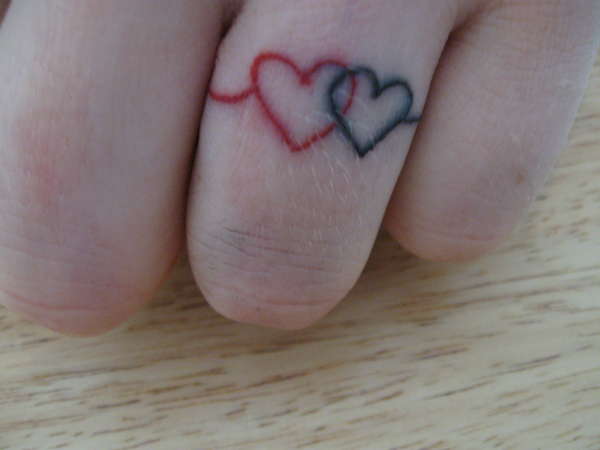 Black And Red Two Little Heart Ring Tattoo On Finger