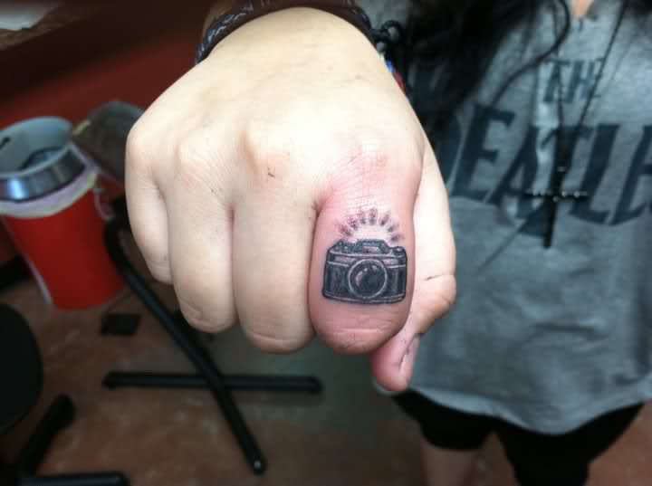 Black Camera Ring Tattoo On Finger