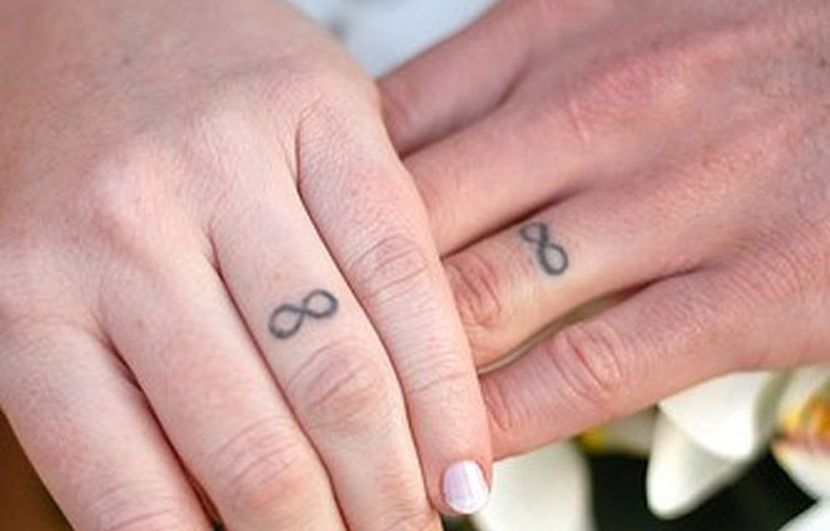Black Infinity Ring Tattoo On Couple Finger