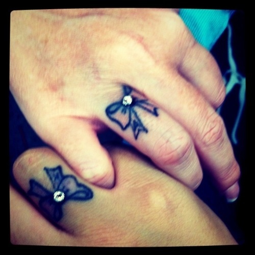 Black Little Bow Tattoo On Couple Finger