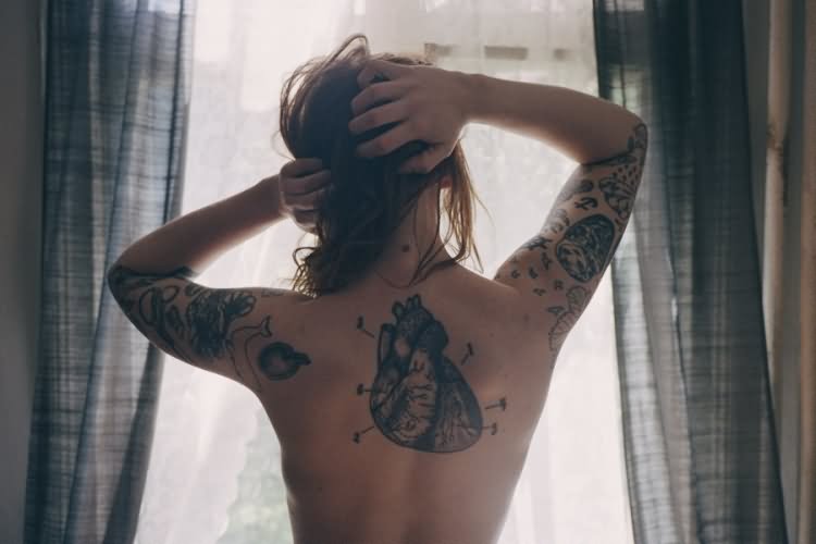 Black Real Heart Tattoo On Girl Upper Back