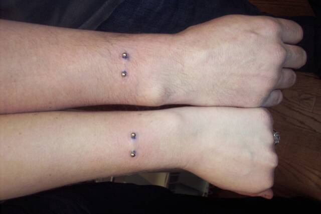Couple Showing Wrist Piercing With Silver Barbell